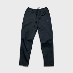 Pantalones deportivos Nike para hombre medianos negros tecnológicos tejidos Swoosh Jogger - Imagen 1 de 10
