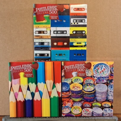 Lot Of 3 PuzzleBug 500 pc Jigsaw Puzzles: Cassette Tapes Colored Pencils, Dishes - Image 1 of 2
