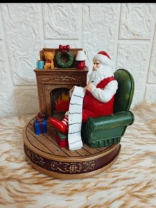 Santa Claus statue tells the Christmas story next to the illuminated fireplace. - Picture 1 of 5