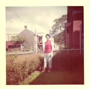Vintage gefundenes Foto 1960er Jahre lockig haarige Frau in rot Shirt Posen im Hinterhof - Bild 1 von 2