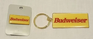 NUOVO OTTONE VINTAGE ANHEUSER BUSCH BUDWEISER BIRRA PORTACHIAVI E CAPPELLO SPILLA - Foto 1 di 1
