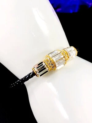 STRIKING 签名 AKKAD 金色黑色皮革织布绳 CUBIC ZIRCONIA 手镯 — 第 1/4 张图片