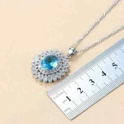 Colgante con halo de topacio azul de corte ovalado de 2 quilates enchapado en oro blanco de 14 quilates plateado Foto 1 de 4