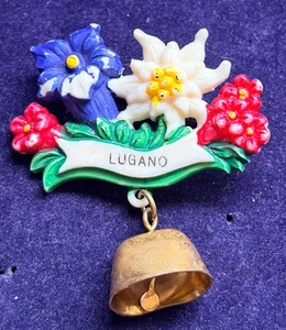 VINTAGE LUGANO SWITZERLAND FLOWERS & COW BELL SOUVENIR PIN BADGE AGE WORN - Picture 1 of 3