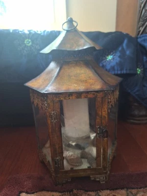 Linterna de metal con vidrio de huracán con hermosa vela Foto 1 de 2