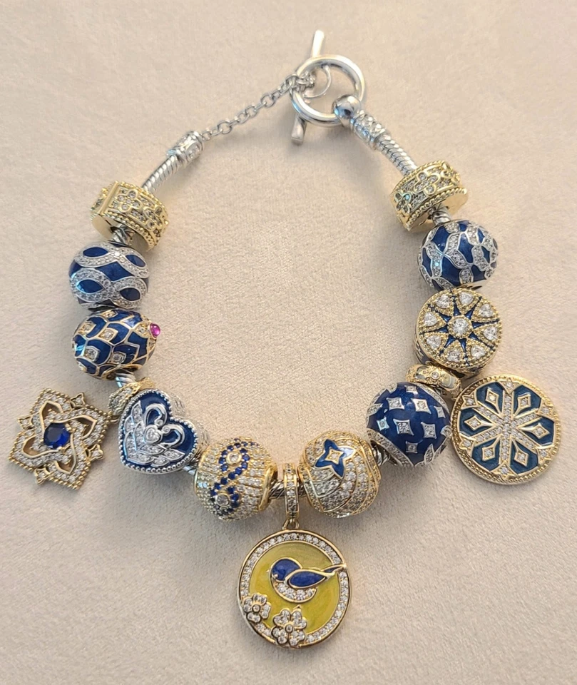 Pulsera de oro blanco de 14k con surtido de dijes. 7,7 pulgadas de largo. Foto 1 de 1