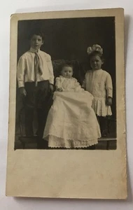 Echt Foto Postkarte RPPC PC entzückend Kinder Baby langes Kleid Mädchen große Schleife X-26 - Bild 1 von 5