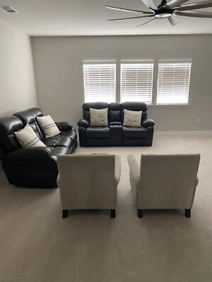 sofá reclinable de cuero negro de dos piezas y dos sillas blancas Foto 1 de 4