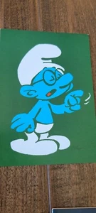 2012 PEYO SMURFS PROMO POSTCARD CARD GREEN VERSION BRAINY SMURF TALKING POINTING - Picture 1 of 1