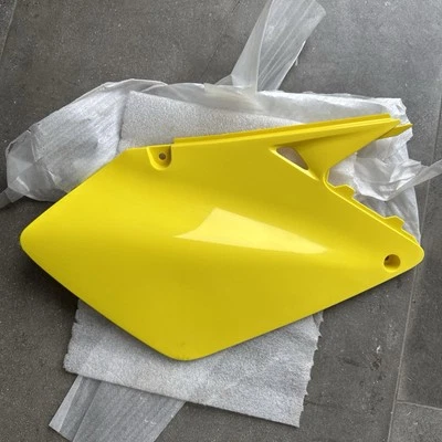 Capa lateral direita Suzuki 2002-2006 RM125 RM250 RM250Z NOS #47211-36F00-YU1 - Imagem 1 de 4