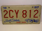1987 South Dakota License Plate 2CY812 Red on White Centennial Expired 12/31/87