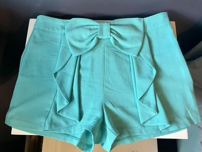 Pantalones cortos con volantes turquesa con acento de moño Foto 1 de 4