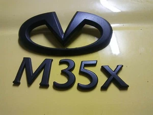 INFINITI M35x EMBLEMA CON LOGO CON PESTAÑAS PINTADO NEGRO - Imagen 1 de 4
