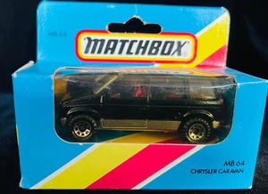 Matchbox-(1-75) - Die-cast - 64f Dodge Caravan Black Silver Strip Light Blue Box - Foto 1 di 1