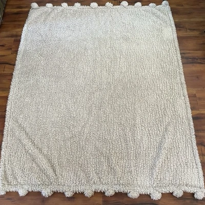 Manta Pottery Barn de piel sintética 50”x60” beige pompones suave y acogedor felpa Foto 1 de 4