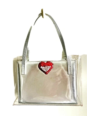 Bolso sin asas de cuero plateado STUART WEITZMAN en un bolso de vinilo transparente con corazón de Swarovski rojo Foto 1 de 4