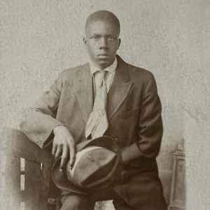 Antiguo RPPC Postal Real Hermoso Estoico Joven Negro Afroamericano Hombre Sombrero - Imagen 1 de 8