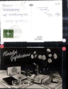 168357, tavolo con radio libri fotocamera cravatta bottiglia profumo pacchetto sigarette B - Foto 1 di 1