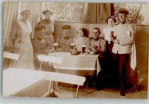 38152494 - 6841 Doebritz Landser in Uniform in Damenbegleitung bei Tische Ort - Bild 1 von 2