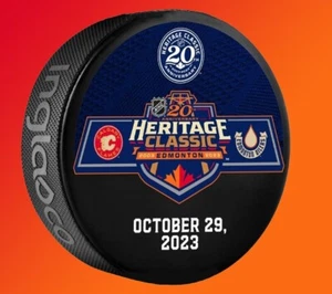 2023 NHL HERITAGE CLASSIC DUELING TEAM PUCK 20TH ANNIVERSARY FLAMES OILERS 10/29 - Picture 1 of 1
