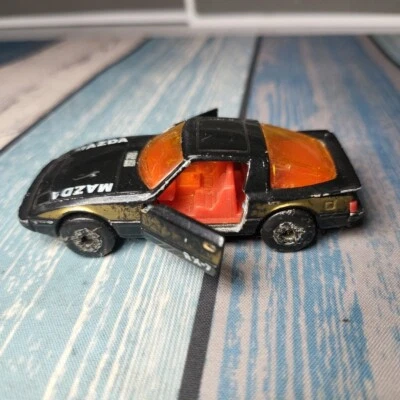 Coche deportivo Mazda RX-7 1982 Matchbox diecast negro y dorado (puertas de apertura) Foto 1 de 4