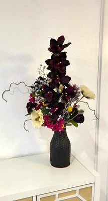 Arreglo Floral Imitación "Moody Darks" con Orquídeas Blanco y Púrpura Oscuro Foto 1 de 4