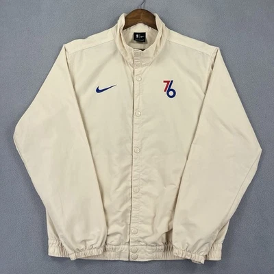 Chaqueta cortavientos Philadelphia 76ers para hombre grande beige botón a presión NBA DNA City Foto 1 de 4