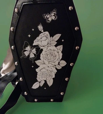 MOCHILA ATAÚD TACHONADA NEGRA HOT TOPIC CON DISEÑO ROSA Y MARIPOSA EN LA PARTE DELANTERA  Foto 1 de 4