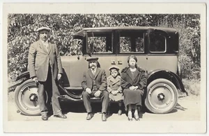 1920 familia inmigrante se sienta sobre rieles de auto, auto - foto real postal vintage - Imagen 1 de 2