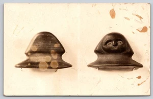 Zwei Ansichten eines kleinen geformten Artefakts mit geschnitztem humanoiden Gesicht & Glockenform RPPC - Bild 1 von 2