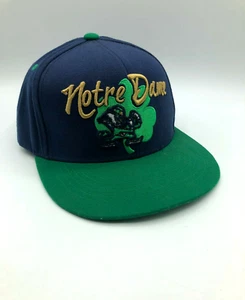 Gorra de béisbol Notre Dame. Verde marino con letras doradas luchando contra el duende irlandés. - Imagen 1 de 8