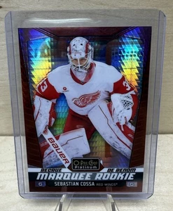 2024-25 O-Pee-Chee Platino Sebastian Cossa Alas Carpa Novato Prisma Rojo/199 - Imagen 1 de 2