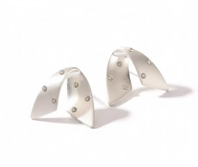 Aretes de metal curvado de circonita cúbica chapados en plata y cobre Foto 1 de 2