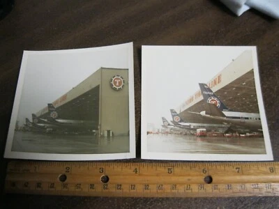 Flying Tigers par de fotos instantâneas de 3 DC-8's em um cabide com logotipo em um dia úmido - Imagem 1 de 3