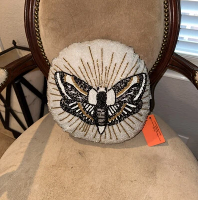 Almohada redonda con cuentas de polilla negra, dorada y blanca con etiquetas Foto 1 de 3