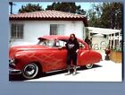 FOUND COLOR PHOTO U+9132 PRETTY WOMAN POSED ON SIDE OF OLD CAR