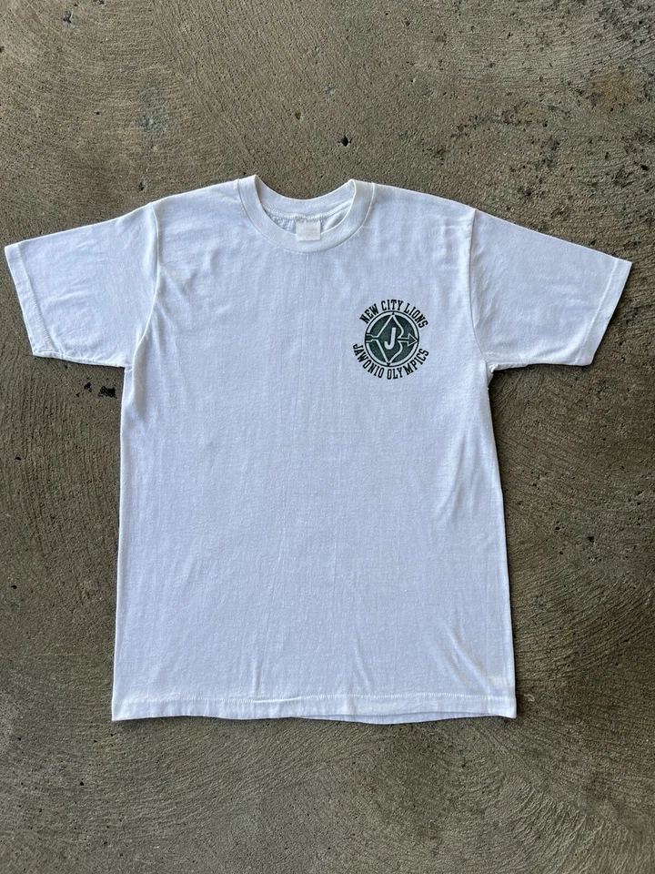 CAMISETA VINTAGE AÑOS 70 80 Jawonio Juegos Olímpicos Nueva Ciudad Leones Blanca Logotipo de Puntada Única Foto 1 de 4