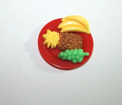 Plato de fruta tamaño muñeca Barbie, plátanos, uvas, piña, en plato rojo Foto 1 de 2