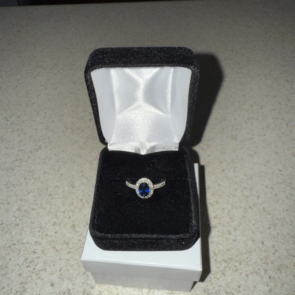 Anillo de diamantes con halo de zafiro azul ovalado de 3/4 quilates de oro blanco de 14 quilates Foto 1 de 1