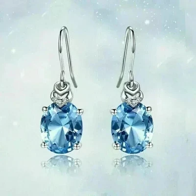 Pendientes colgantes de topacio azul creados en laboratorio de corte ovalado de 3 quilates enchapados en oro blanco de 14 quilates Foto 1 de 4