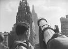 Tourists at Bryant Park looking through a telescope towards Americ- Old Photo