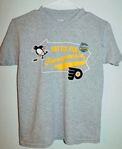 "Camisetas medianas para jóvenes ""Battle for Pennsylvania"" de la NHL (Voladores/pingüinos)" - Imagen 1 de 1