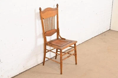 Antigua silla de comedor o silla lateral con husillo trasero prensado de roble tallado americano Foto 1 de 4