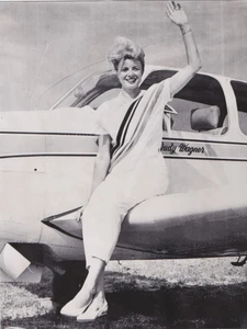 Foto de prensa 1963 mujer piloto Judy Wagner sentada en su avión en carrera aérea - Imagen 1 de 2