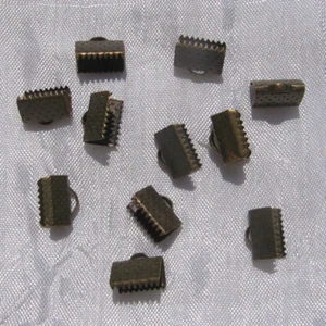 J11 - LOT DE 100 EMBOUTS PINCES ATTACHE RUBAN À GRIFFES GROS GRAIN 10MM BRONZE - Picture 1 of 3