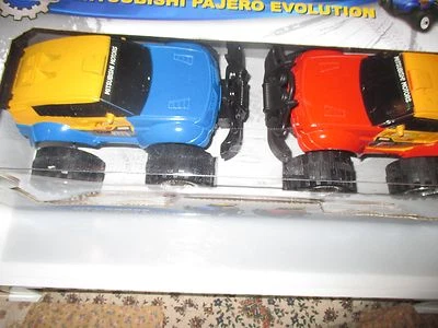 ВНЕДОРОЖНИК MITSUBISHI PAJERO EVOLUTION, НАБОР ИЗ 2 СПОРТИВНЫХ ГРУЗОВИКОВ С ФРИКЦИОННЫМ ПРИВОДОМ, КРАСНЫЙ, СИНИЙ - Изображение 1 из 4