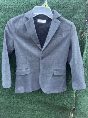La imagen muestra una chaqueta blazer para niño de la marca H&M. El blazer es gris, Foto 1 de 4