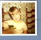 FOUND COLOR PHOTO I+8289 LITTLE BOY SITTING AT TABLE SMILING HOLDING TOY CAR