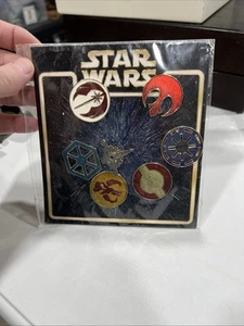 NUOVO Disney Pin 77127 Mini-Pin Collezione Star Wars Emblemi Set 7 Spille Jedi Rebel - Foto 1 di 11
