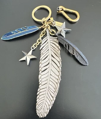 RARO Y DIFÍCIL DE ENCONTRAR USADO Bolso Coach Mixto Plumas y Estrellas Dije Latón Foto 1 de 4